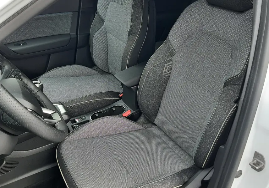 Vue intérieure côté gauche du Renault Symbioz blanc nacré 2025, sièges tissu gris avec surpiqûres claires.