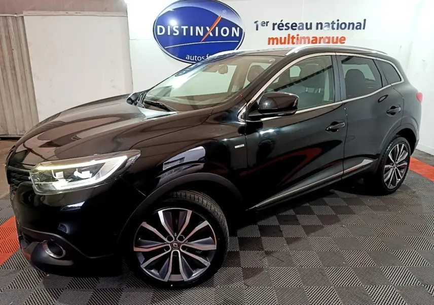 Renault Kadjar Intens noir en 3/4 avant droit, avec jantes alliage et phares LED allumés dans un showroom.