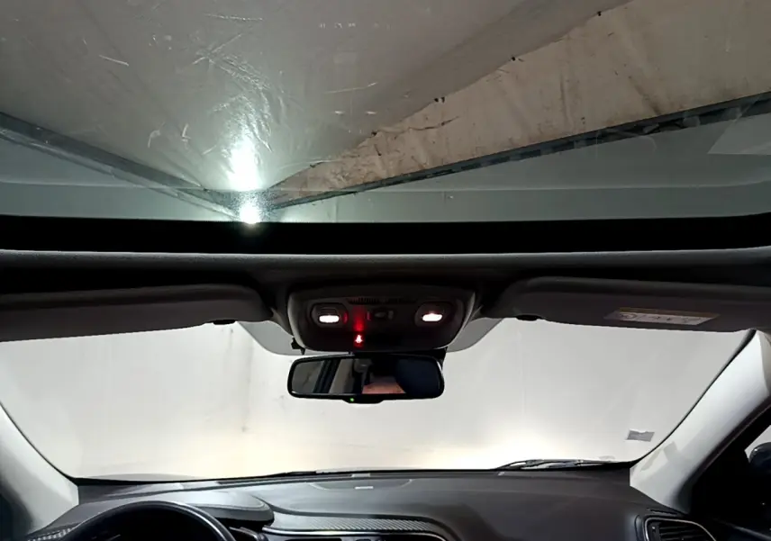 Vue intérieure avant du Renault Kadjar noir 2018, montrant le tableau de bord et le rétroviseur central avec plafonnier allumé.