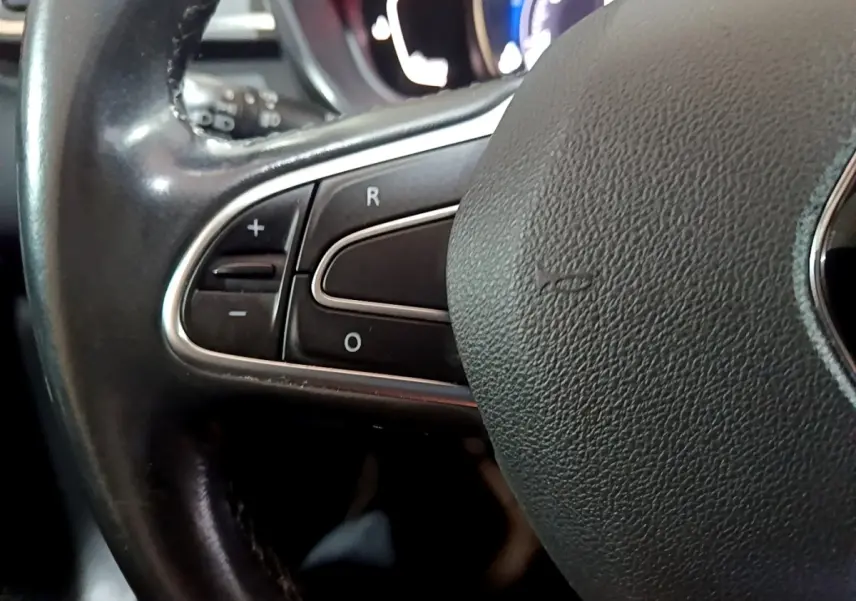 Gros plan sur la partie gauche du volant cuir noir du Renault Kadjar Intens 2018 avec commandes intégrées.