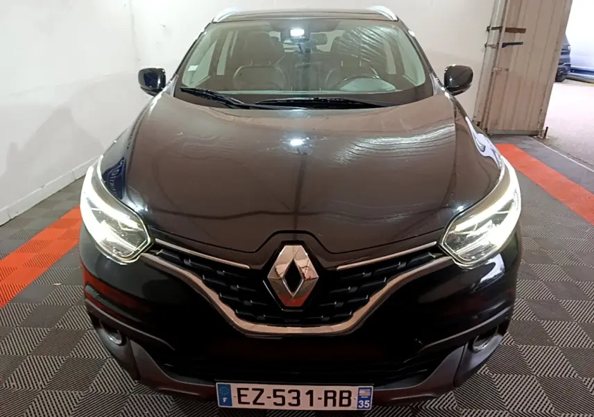 Vue frontale d'un Renault Kadjar Intens noir avec phares LED allumés dans un garage intérieur.