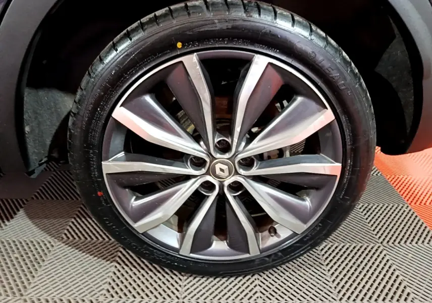 Gros plan sur la jante alliage du Renault Kadjar noir, soulignant le design moderne à branches bicolores.