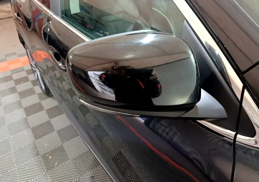 Rétroviseur côté gauche noir brillant du Renault Kadjar Intens Energy TCe 130, vue rapprochée sur la portière noire.