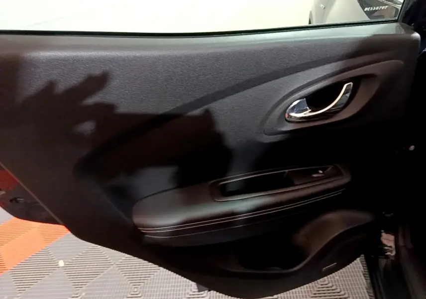 Gros plan sur la porte intérieure arrière droite noire du Renault Kadjar Intens 2018 avec poignée chromée et accoudoir.