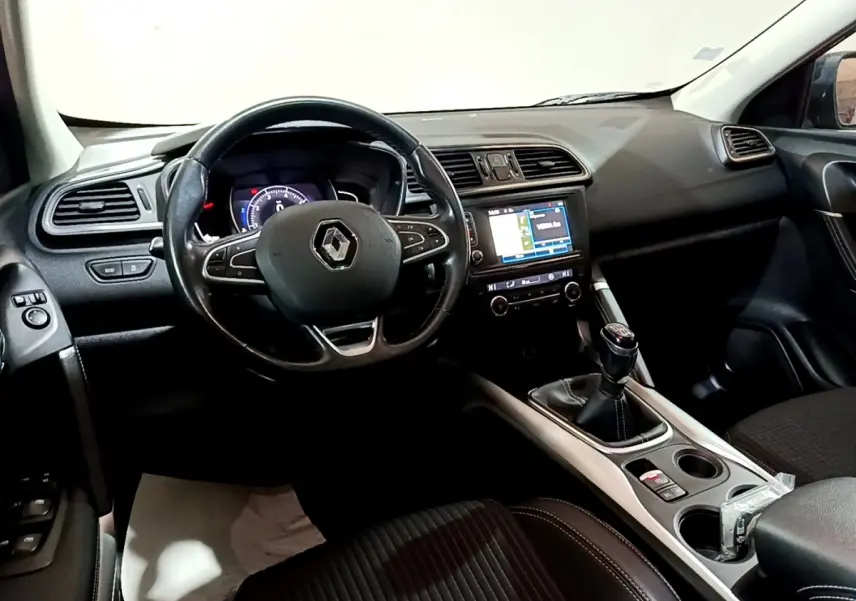 Intérieur noir du Renault Kadjar Intens 2018 vu côté conducteur, volant cuir, écran tactile et boîte manuelle visibles.