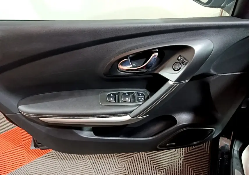 Vue rapprochée de la porte avant gauche noire du Renault Kadjar Intens avec commandes de vitres et poignée chromée.