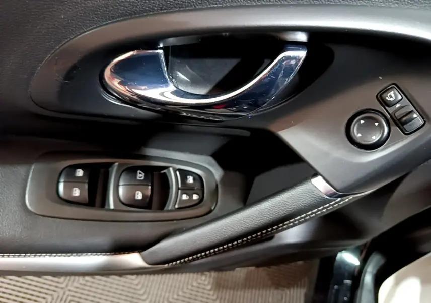 Poignée de porte intérieure chromée et commandes des vitres côté conducteur du Renault Kadjar Intens noir de 2018.