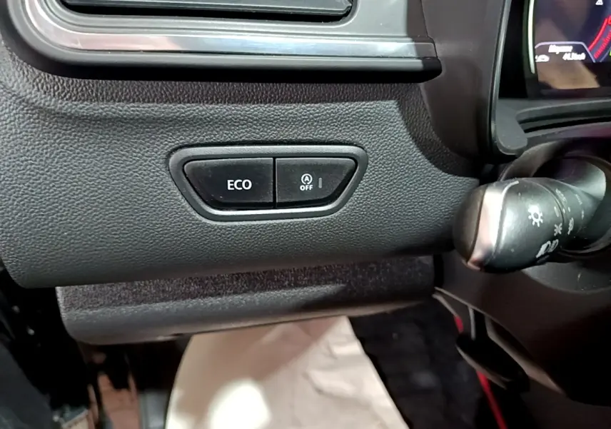 Gros plan sur les boutons ECO et arrêt auto start du tableau de bord noir du Renault Kadjar Intens 2018.