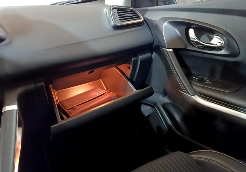 Intérieur côté passager du Renault Kadjar Intens 2018, boîte à gants ouverte avec éclairage intérieur orange.