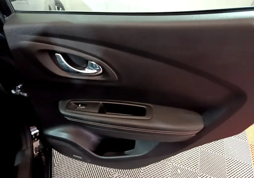 Panneau intérieur noir côté gauche de la porte avant Renault Kadjar Intens 2018 avec poignée chromée et commande de vitre.