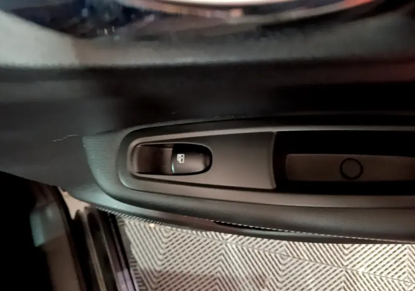 Gros plan sur le bouton de verrouillage des portes côté gauche dans l'habitacle noir du Renault Kadjar Intens 2018.