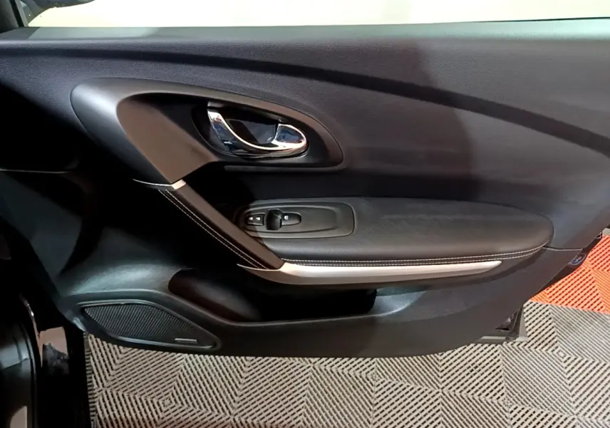 Porte intérieure côté gauche noire du Renault Kadjar Intens 2018 avec poignée chromée et commandes de vitres.