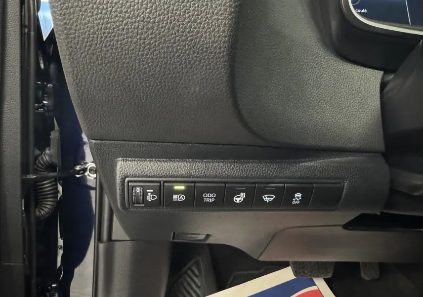 Vue intérieure du tableau de bord côté gauche du Suzuki Swace bleu 2025, montrant les commandes de réglage et assistance.