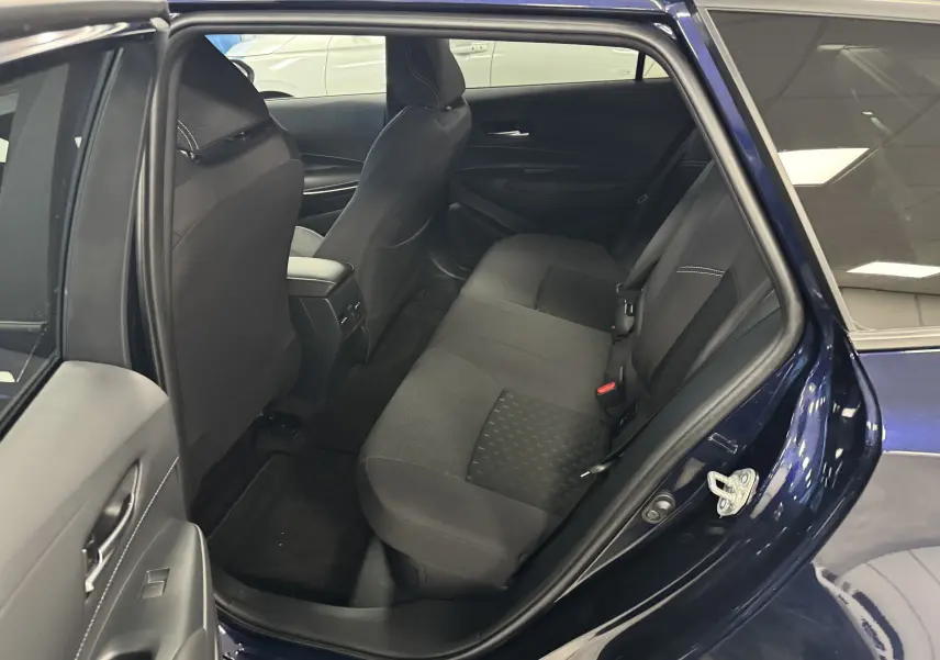 Vue intérieure côté gauche sur la banquette arrière noire d’une Suzuki Swace bleu 2025 avec porte ouverte.