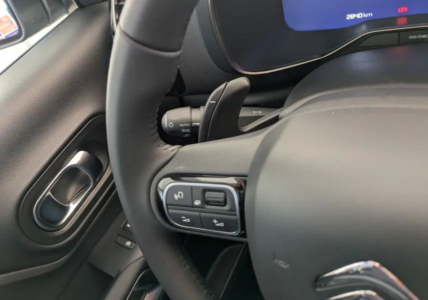 Gros plan sur le volant en cuir noir et la commande multifonction côté gauche du tableau de bord d'un Citroën C5 Aircross 2025.