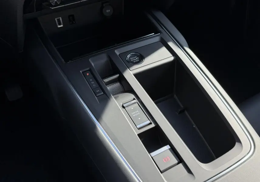 Vue rapprochée de la console centrale noire du Citroën C5 Aircross 2025 avec bouton start/stop et sélecteur de mode de conduite.