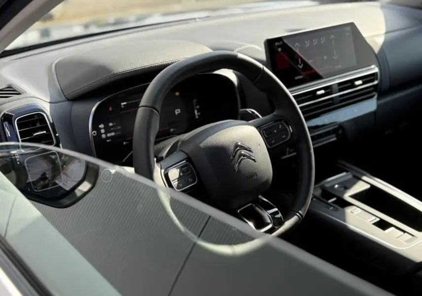 Vue intérieure côté conducteur du Citroën C5 Aircross 2025, volant cuir noir et tableau de bord numérique avec écran tactile.