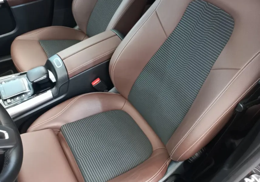 Gros plan intérieur sur les sièges avant marron et noir du Mercedes GLA 200 Business Line 2021, avec console centrale visible.