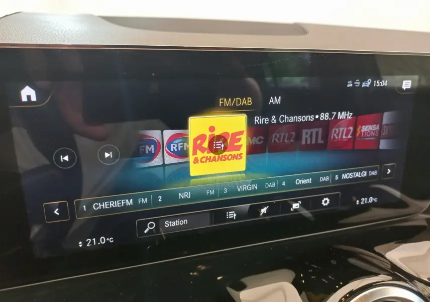Écran tactile central du tableau de bord d’une Mercedes GLA 200 Business Line gris foncé, affichant les radios FM/DAB.