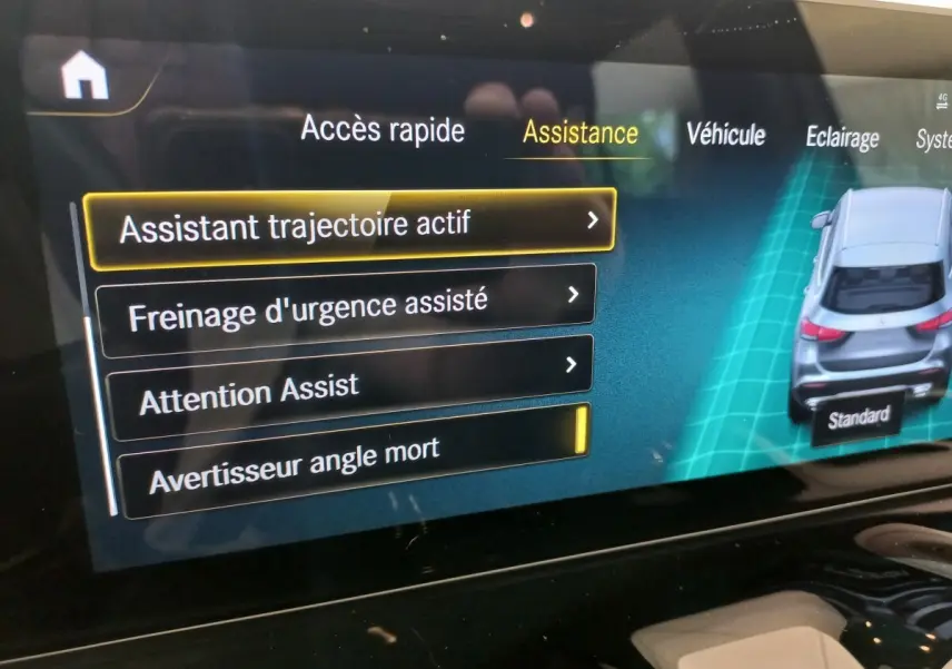 Écran tactile intérieur montrant les options d'assistance avec une vue arrière 3D d'un Mercedes GLA gris foncé.