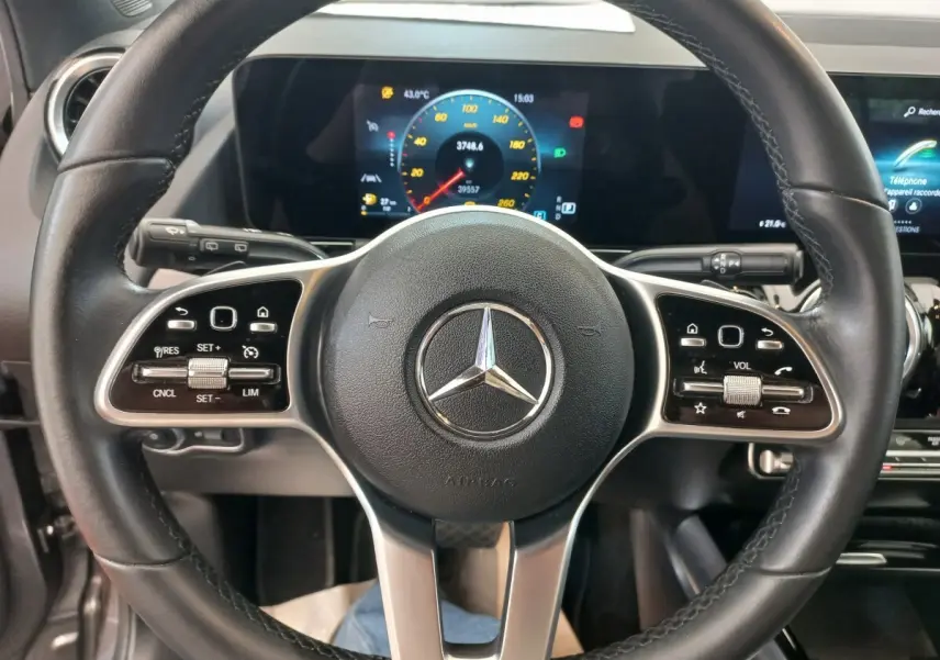 Vue rapprochée du volant cuir noir d’une Mercedes GLA 200 Business Line 2021 avec tableau de bord numérique coloré.