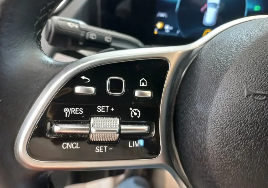 Gros plan sur les commandes au volant cuir noir du Mercedes GLA 200 Business Line 2021, avec boutons multifonctions.
