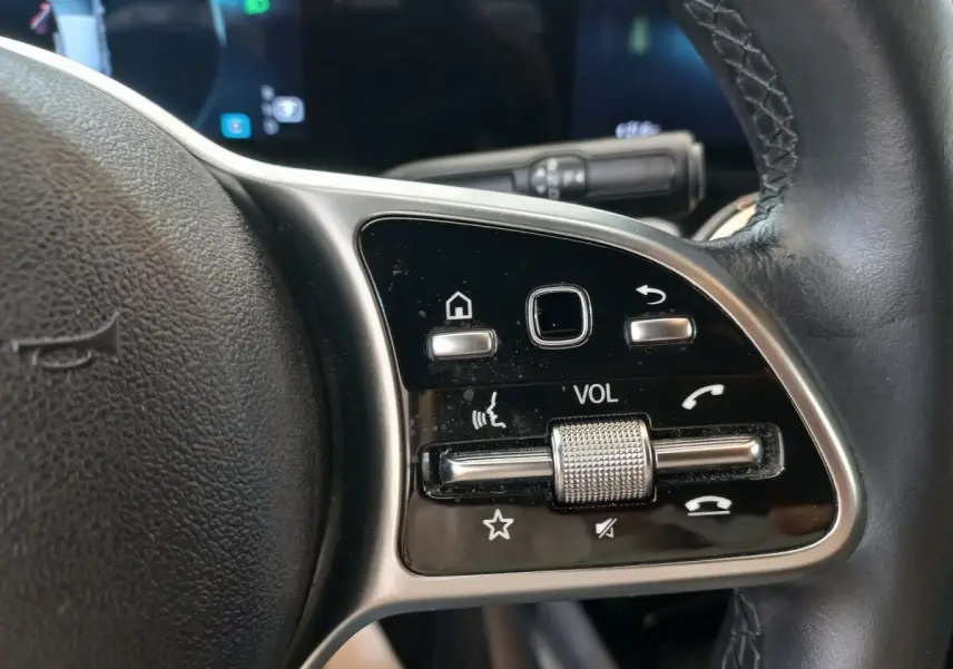 Gros plan sur les commandes multifonctions du volant cuir à droite du Mercedes GLA 200 Business Line gris foncé, 2021.