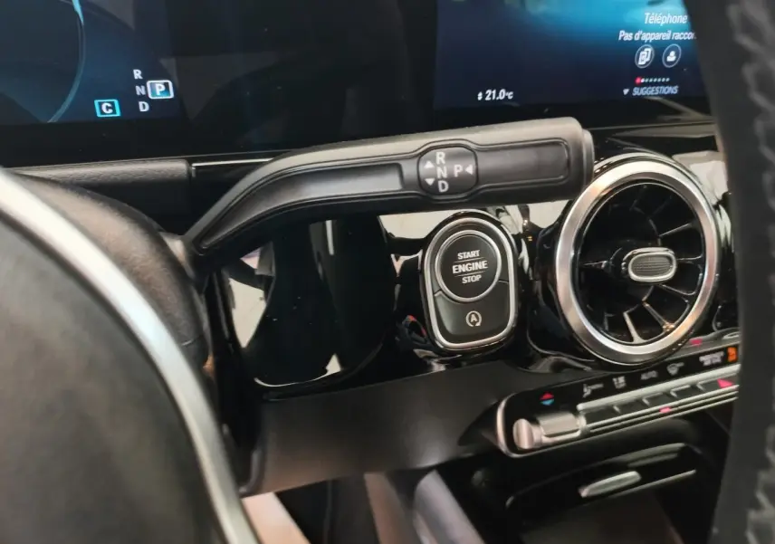 Gros plan sur le tableau de bord noir du Mercedes GLA 200, avec bouton start/stop et commande de boîte automatique.