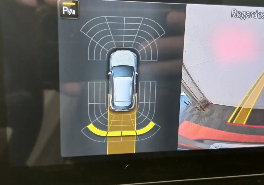 Affichage intérieur de la caméra de recul et capteurs de stationnement du Mercedes GLA 200 gris foncé en vue aérienne.