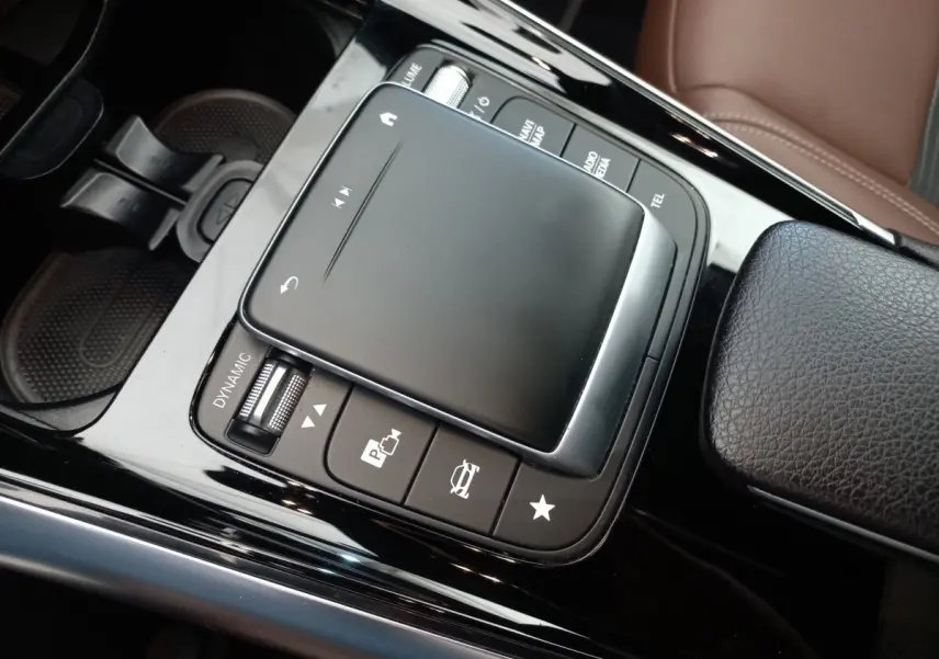 Gros plan sur la console centrale noire brillante du Mercedes GLA 200 Business Line 2021 avec pavé tactile et commandes.