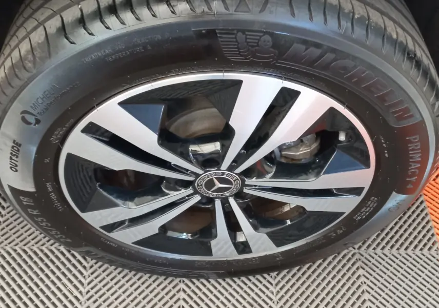 Gros plan sur la jante alliage bicolore noir et argent avec logo Mercedes d’une Mercedes GLA gris foncé.