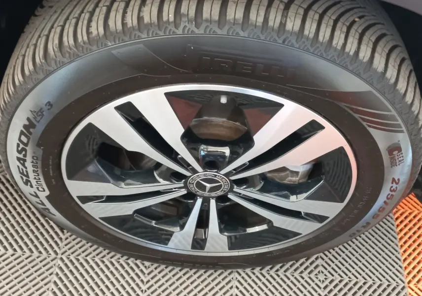 Gros plan sur la roue avant avec jante alliage bicolore noir et argent du Mercedes GLA gris foncé 2021.