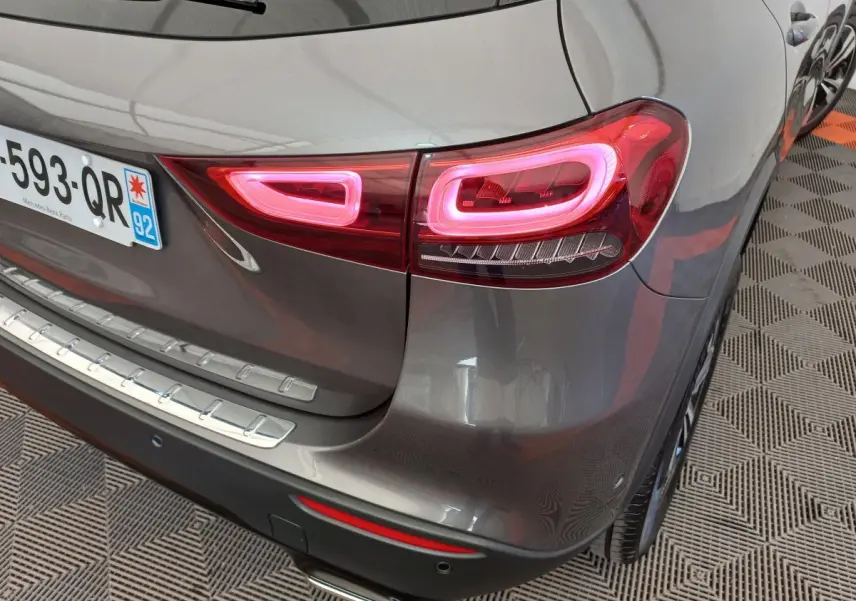 Feu arrière droit allumé d’un Mercedes GLA 200 Business Line gris foncé, vue en gros plan sur le coin arrière.