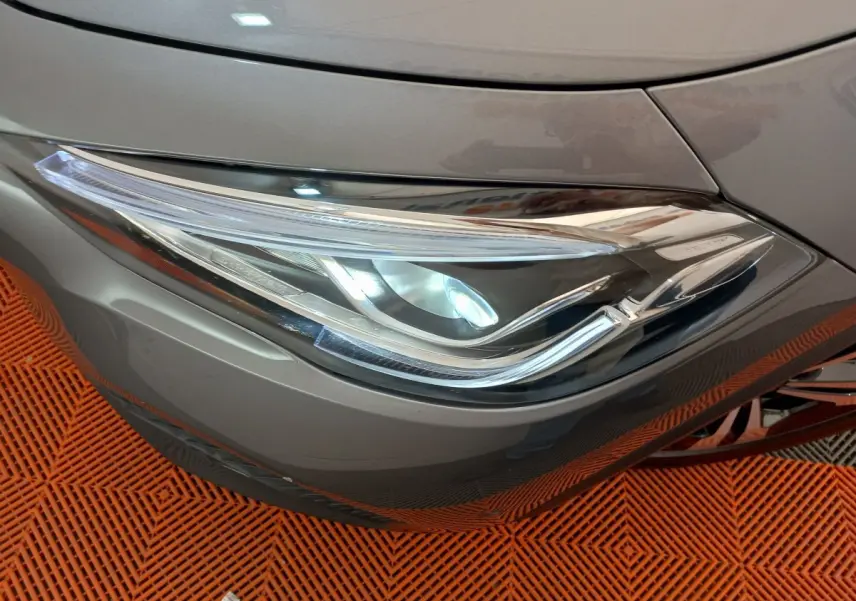 Gros plan sur le phare avant droit gris foncé d'une Mercedes GLA 200 Business Line 2021, détails LED visibles.