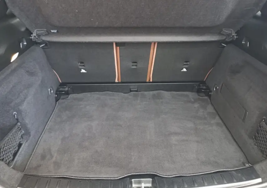 Coffre ouvert vu de face d’un Mercedes GLA 200 Business Line 2021, revêtement intérieur gris foncé avec filets latéraux.