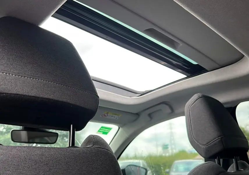 Vue intérieure arrière montrant les appuie-têtes noirs et le toit ouvrant panoramique du Citroën C4 gris 2024.