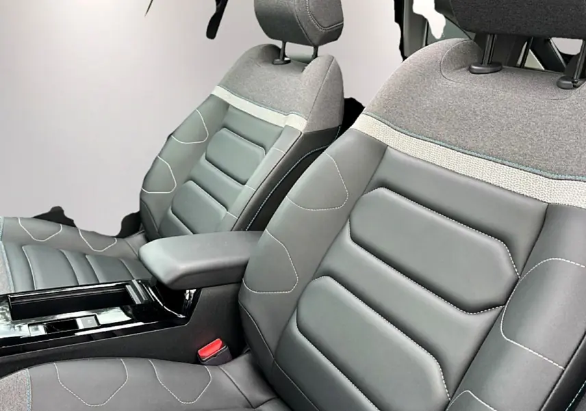 Gros plan sur les sièges avant gris bi-matière avec accoudoir central dans l'habitacle d'une Citroën C4 2024.