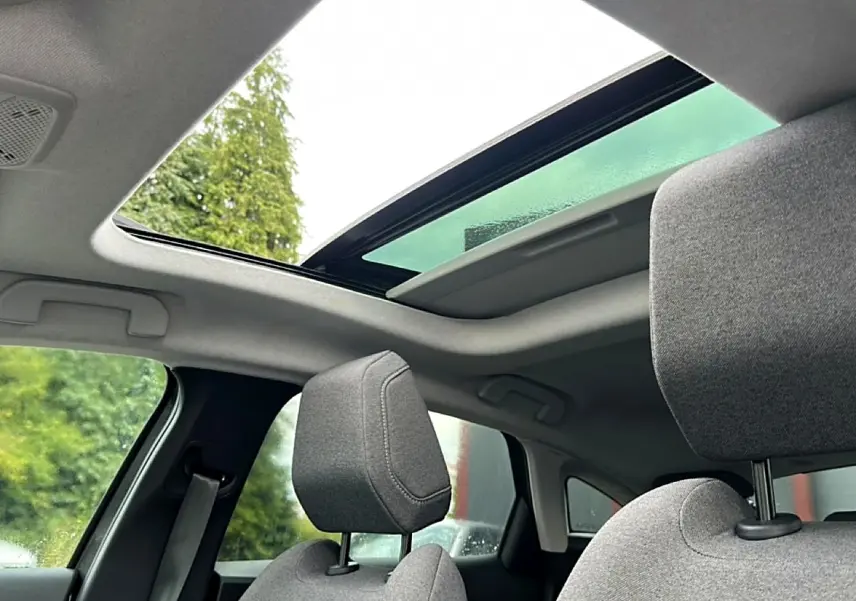Vue intérieure sur les sièges avant gris et le toit ouvrant panoramique partiellement ouvert du Citroën C4 2024.