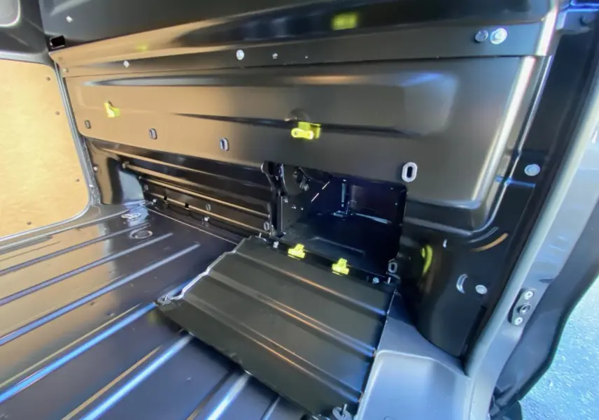 Vue intérieure du compartiment de chargement du Peugeot Expert Fourgon gris titane, montrant une trappe de charge ouverte avec fixations jaunes.