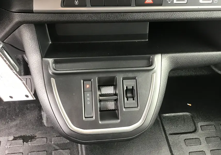 Gros plan sur la console centrale du Citroën Jumpy gris titane, montrant la commande de boîte automatique et les commandes de climatisation.