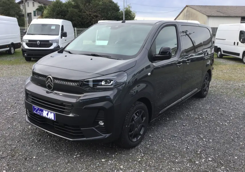 Citroën Jumpy cabine approfondie gris titane en 3/4 avant droit avec calandre noire et jantes foncées sur parking.