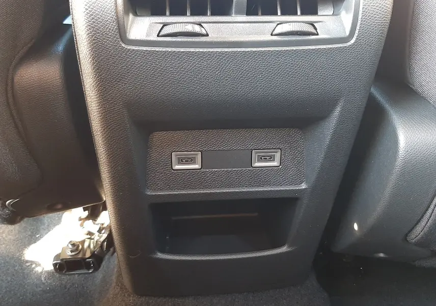 Prise USB double et bouche d'aération arrière sur console centrale noire d'une Peugeot 308 Bleu Obsession 2025.