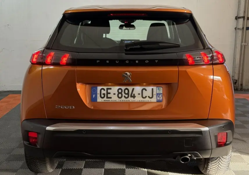 Vue arrière d'un Peugeot 2008 orange 2022 avec feux LED caractéristiques et plaque d'immatriculation française.