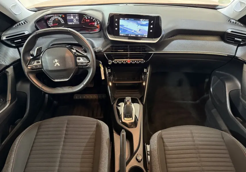 Vue intérieure avant du Peugeot 2008 2022, tableau de bord avec écran tactile central et volant cuir multifonctions noir.