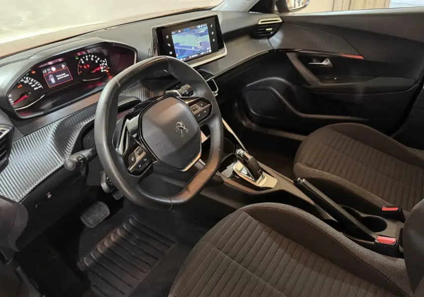 Vue intérieure côté conducteur du Peugeot 2008 2022, tableau de bord avec écran tactile et volant cuir noir.