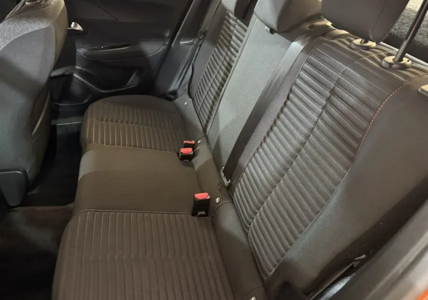 Vue intérieure côté arrière droit montrant la banquette noire du Peugeot 2008 orange, avec ceinture et appuie-têtes visibles.