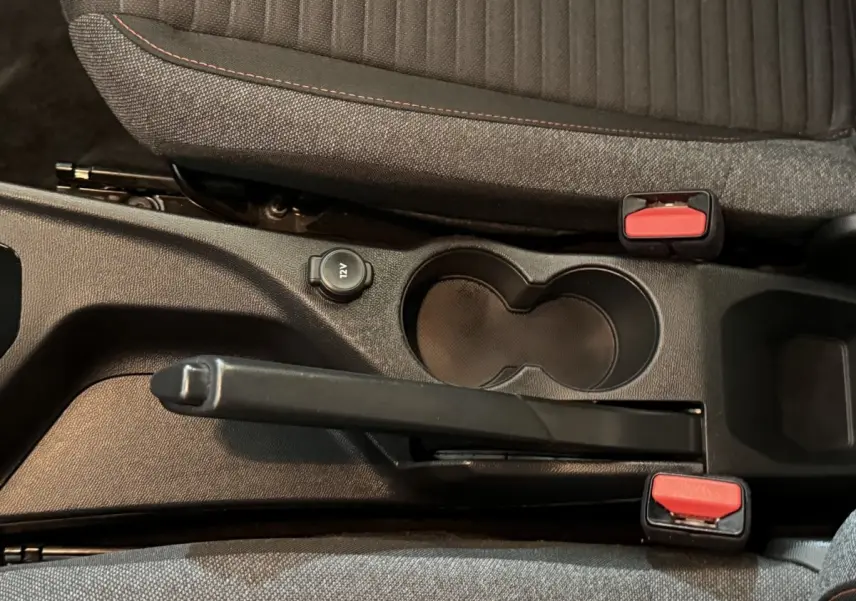 Vue rapprochée de la console centrale noire du Peugeot 2008 avec frein à main manuel et porte-gobelets.