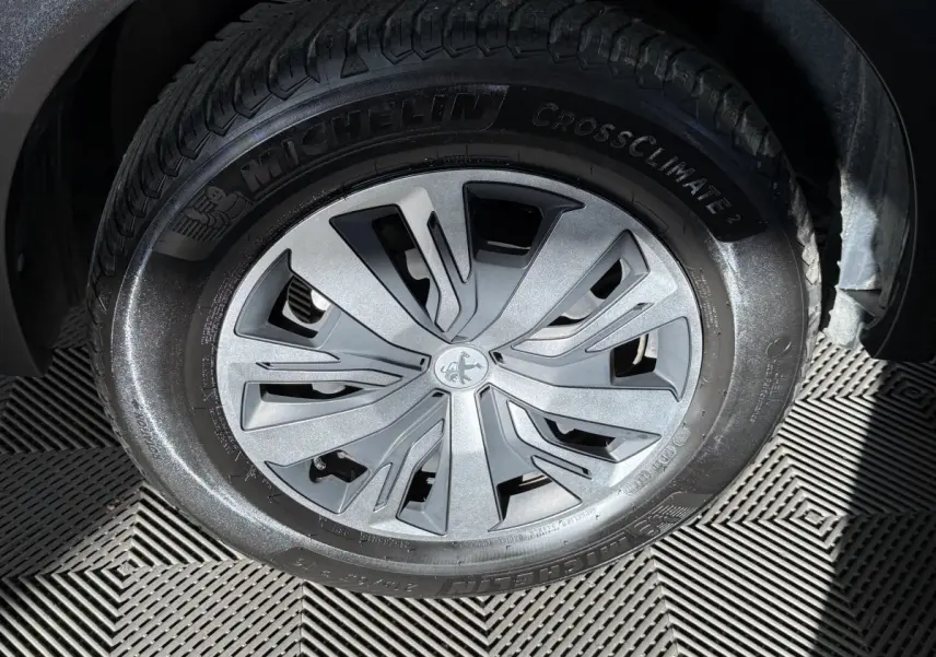 Gros plan sur la roue avant droite d’un Peugeot 2008 orange, mettant en valeur la jante aluminium et le pneu Michelin.