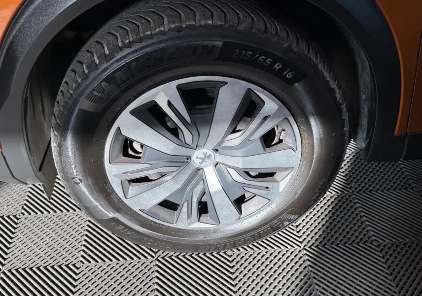 Gros plan sur la roue avant droite orange du Peugeot 2008 avec jante en alliage et pneu Michelin.
