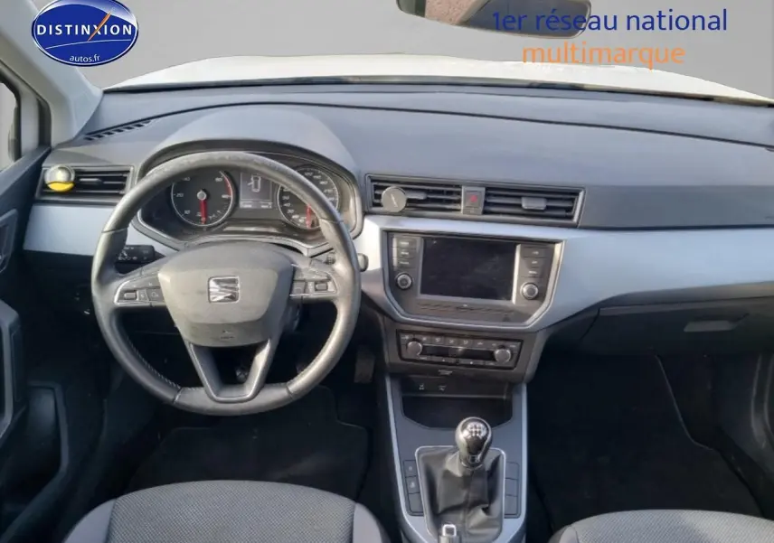 Vue intérieure du tableau de bord et volant cuir du SEAT Arona 1.6 TDI 115 style, avec écran tactile et levier de vitesse manuel.
